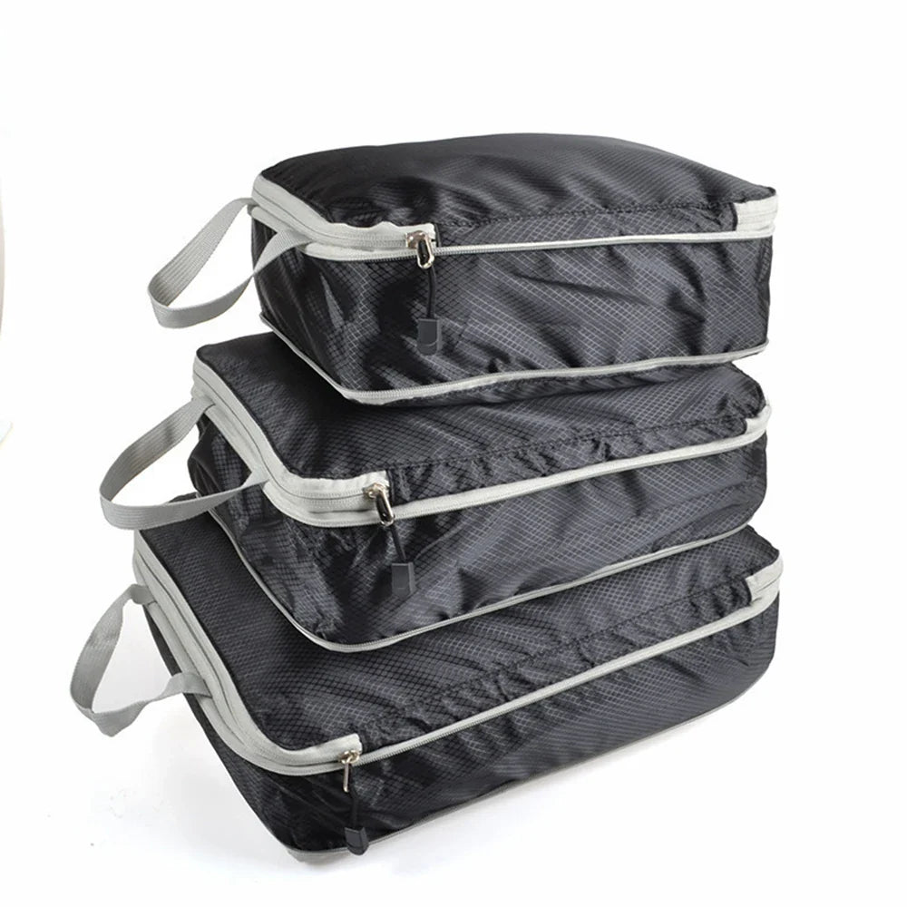 Set of three compression packing bags in black, with additional colors shown in blue and gray. Each bag has a zipper closure and a mesh side panel.