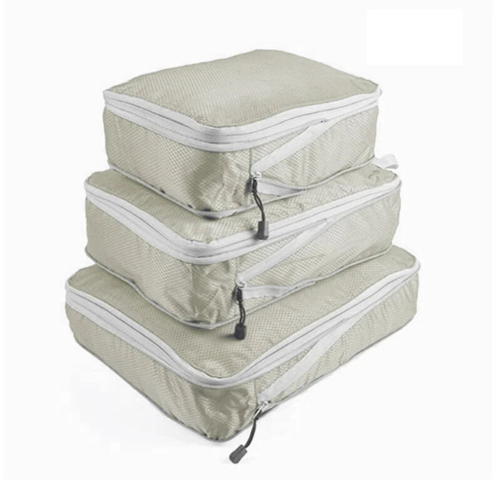 Set of three compression packing bags in black, with additional colors shown in gray. Each bag has a zipper closure and a mesh side panel.