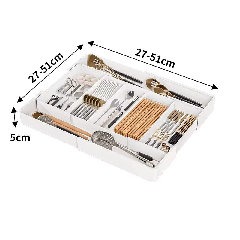 Extendable drawer organizer with various compartments filled with cutlery and kitchen utensils, fitted in an open drawer.