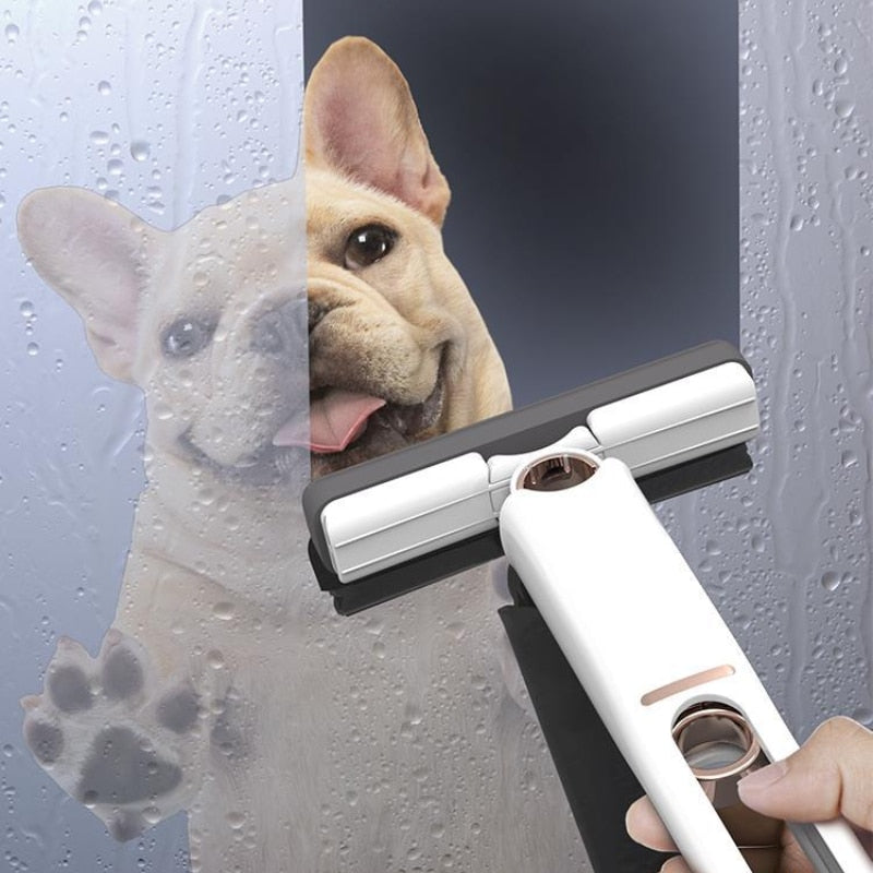 The image shows a Mini Mop foldable being used to clean a window with a dog looking curiously in the background.