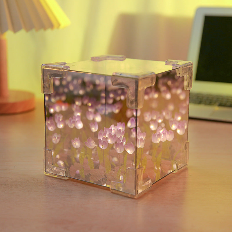 Two LED tulip cubes with multicolored lights, placed on a table, showcasing the floral design within the transparent material.