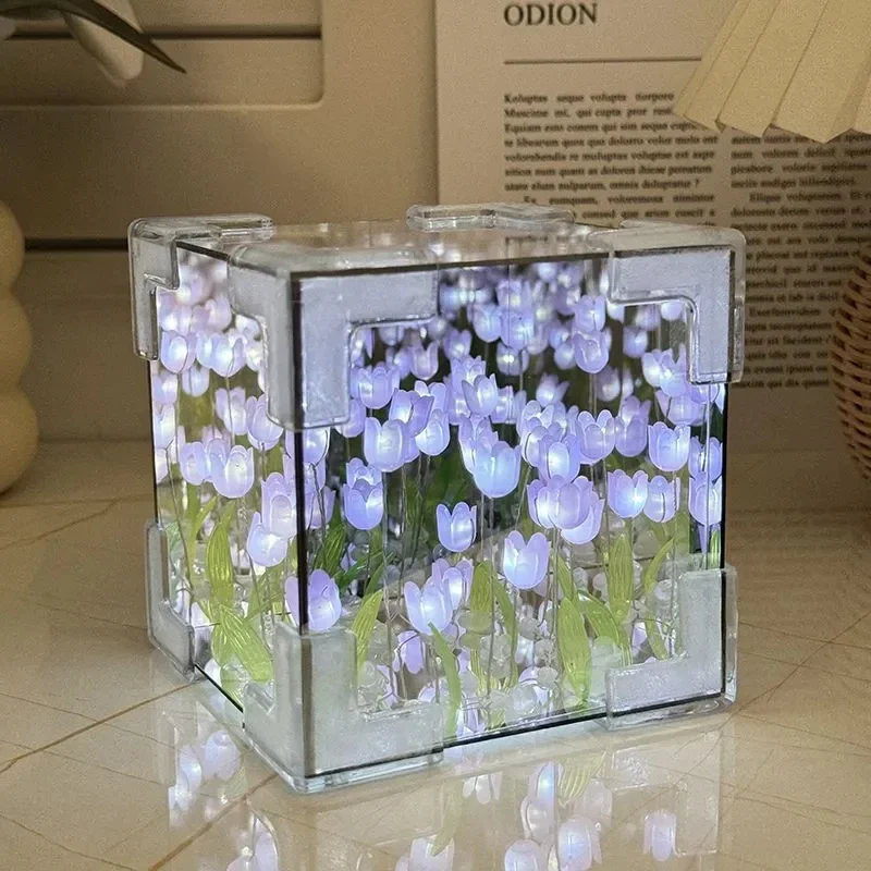 Two LED tulip cubes with multicolored lights, placed on a table, showcasing the floral design within the transparent material.