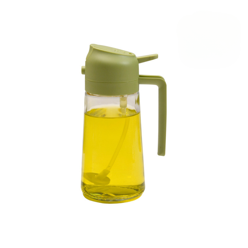 Clear glass bottle with green lid and handle filled with a yellow liquid on a white background