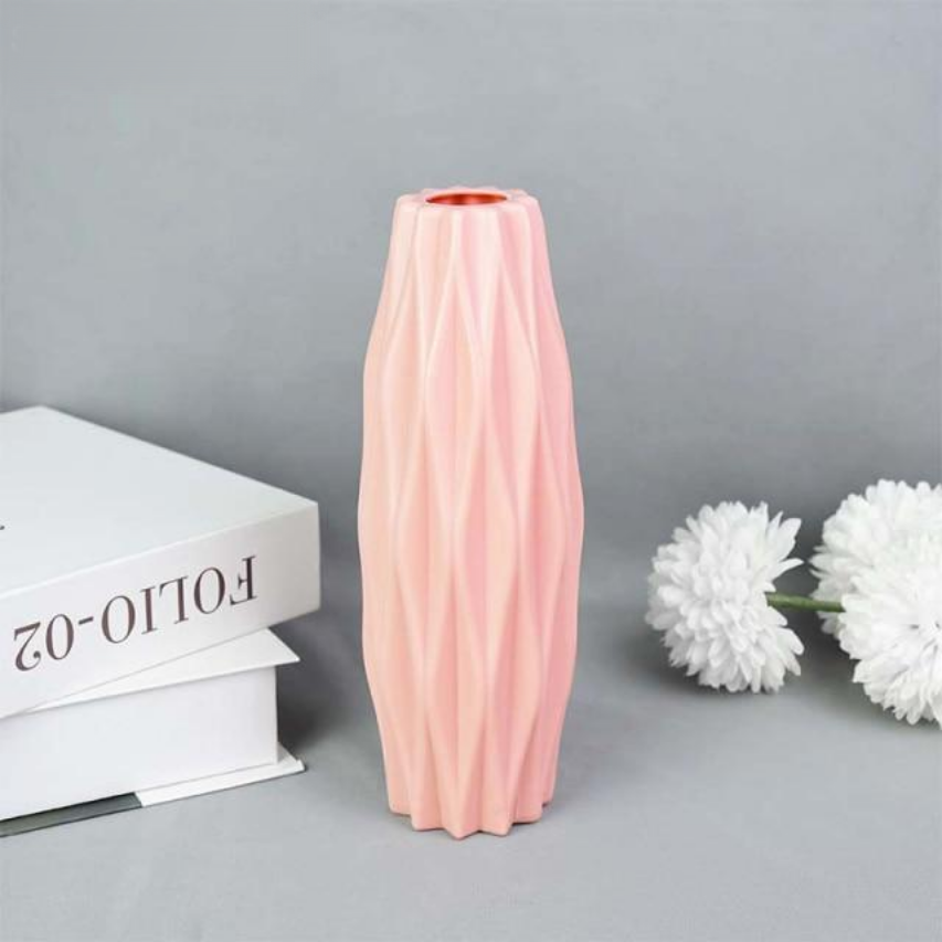 A collection of origami vases in white, pink, and turquoise colors displayed with flowers.