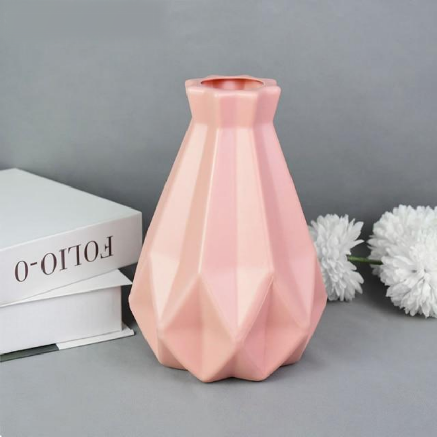 A collection of origami vases in white, pink, and turquoise colors displayed with flowers.