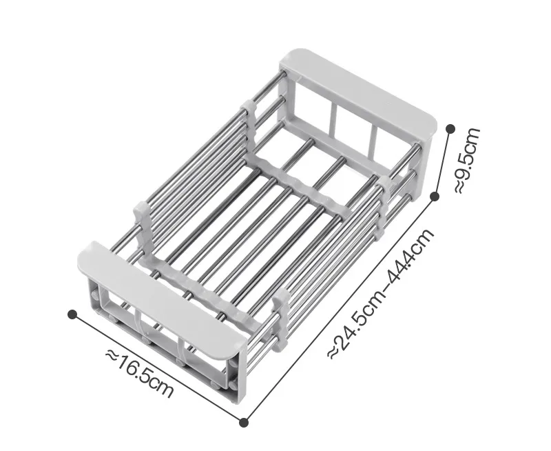 A stainless steel sink basket with telescopic rods being adjusted to fit inside a sink, with dishes and vegetables placed on it.