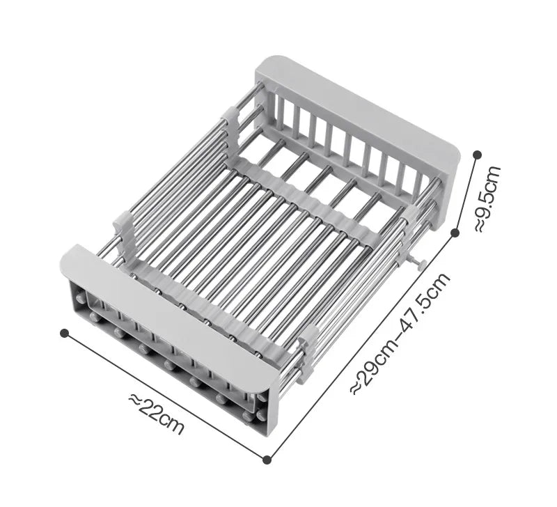 A stainless steel sink basket with telescopic rods being adjusted to fit inside a sink, with dishes and vegetables placed on it.