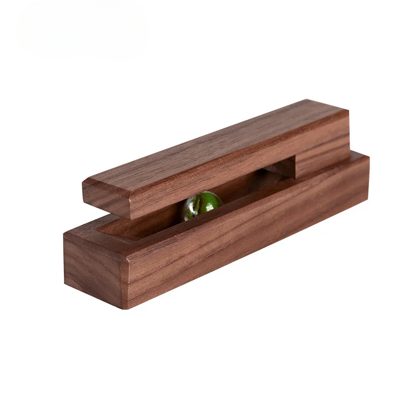 Wooden block with a small green ball inside on a white background