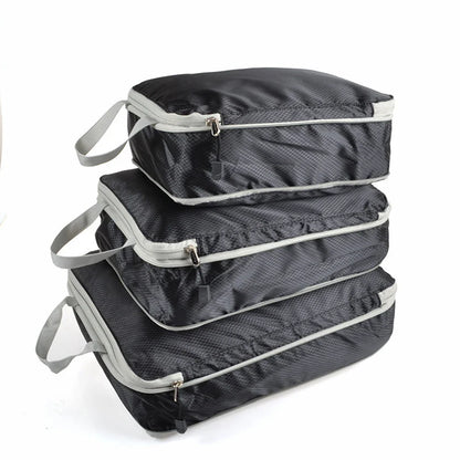 Set of three compression packing bags in black, with additional colors shown in blue and gray. Each bag has a zipper closure and a mesh side panel.