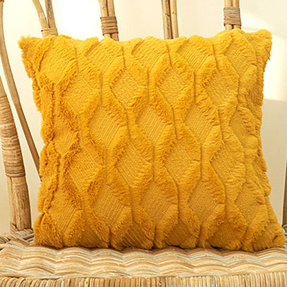 A collection of various colored cushion covers displayed on a wooden stool and the floor, with a few cushions inserted into the covers showcasing a textured design.
