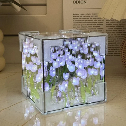 Two LED tulip cubes with multicolored lights, placed on a table, showcasing the floral design within the transparent material.