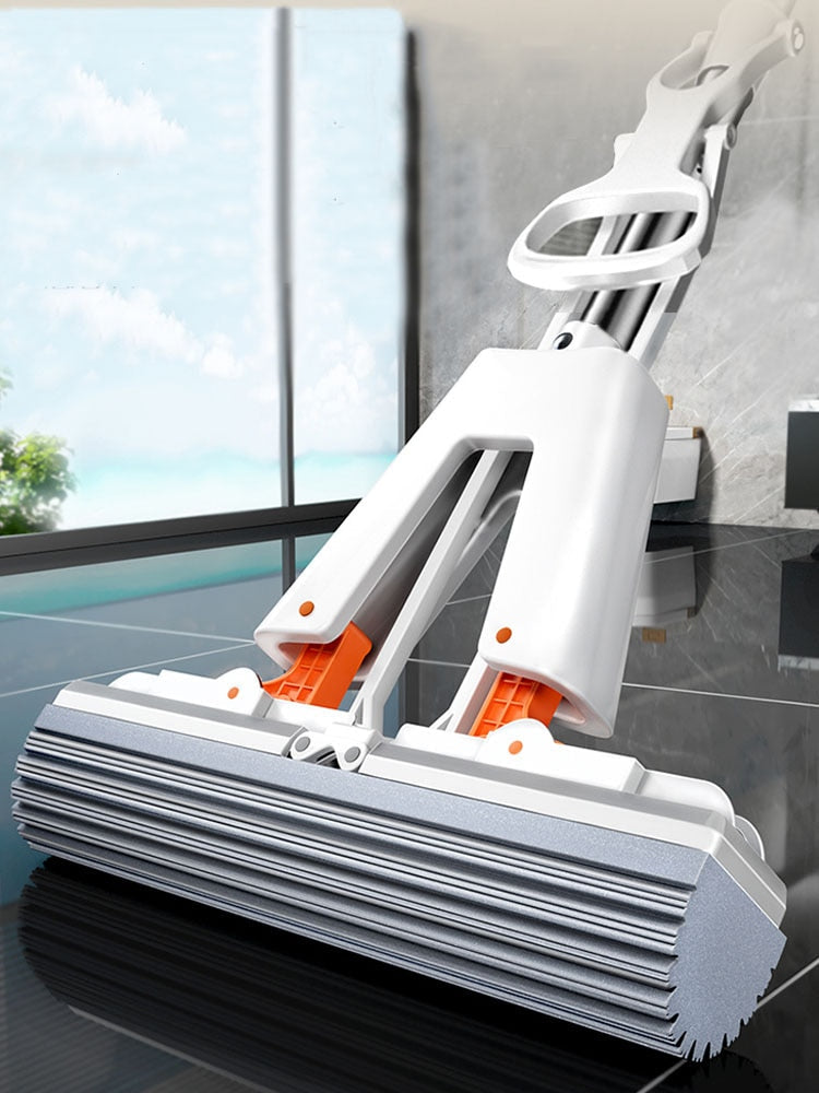 A white mop with orange sponge attachments, featuring a wringing mechanism and an adjustable handle, standing upright on a floor.