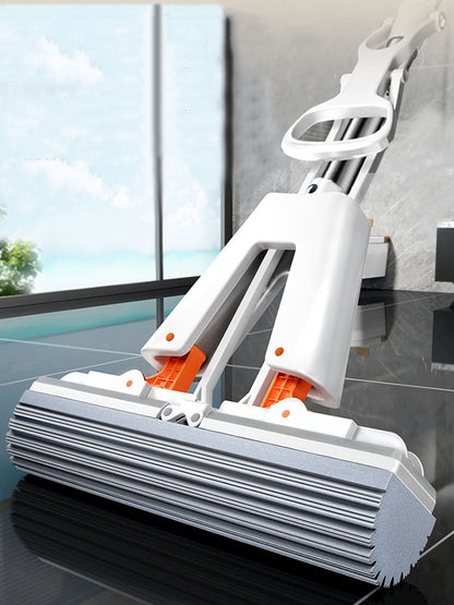 A white mop with orange sponge attachments, featuring a wringing mechanism and an adjustable handle, standing upright on a floor.