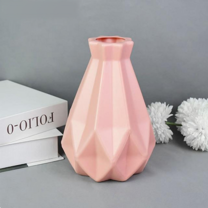 A collection of origami vases in white, pink, and turquoise colors displayed with flowers.