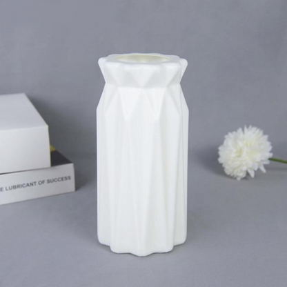 A collection of origami vases in white, pink, and turquoise colors displayed with flowers.