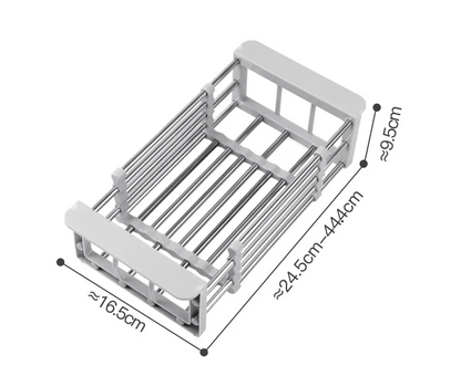 A stainless steel sink basket with telescopic rods being adjusted to fit inside a sink, with dishes and vegetables placed on it.