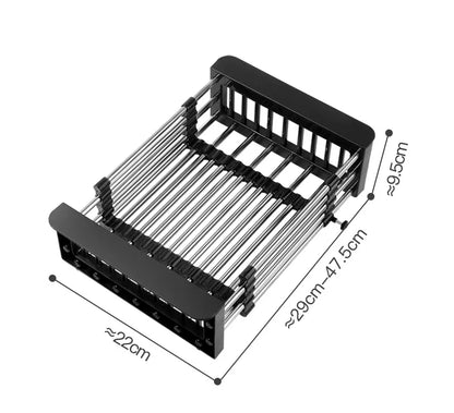 A stainless steel sink basket with telescopic rods being adjusted to fit inside a sink, with dishes and vegetables placed on it.