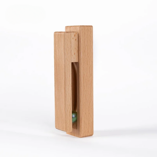 Wooden block with a small green ball inside on a white background